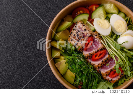 Seafood bowl, tuna tataki fillet slices with rice, oranges, tomatoes and sauce. Tuna bowl 132348130