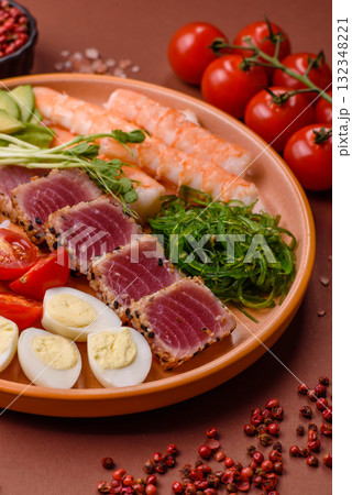 Seafood bowl, tuna tataki fillet slices with rice, oranges, tomatoes and sauce. Tuna bowl Seafood bowl, tuna tataki fillet slices with rice, oranges, tomatoes and sauce. Tuna bowl 132348221