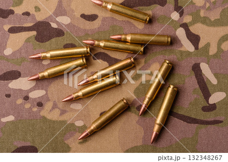Machine gun cartridges on a camouflage background, military wallpaper. Camouflage background 132348267