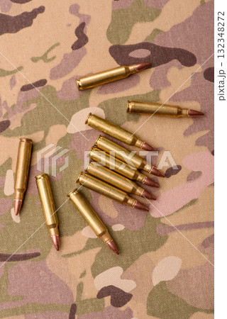 Machine gun cartridges on a camouflage background, military wallpaper. Camouflage background Machine gun cartridges on a camouflage background, military wallpaper. Camouflage background 132348272