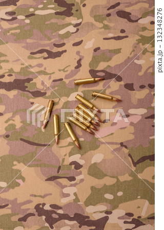 Machine gun cartridges on a camouflage background, military wallpaper. Camouflage background 132348276