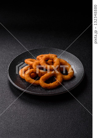 Onion rings or fried squid in breadcrumbs with sauce, takeaway food. Onion rings fried 132348880