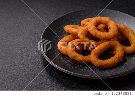 Onion rings or fried squid in breadcrumbs with sauce, takeaway food. Onion rings fried 132348881