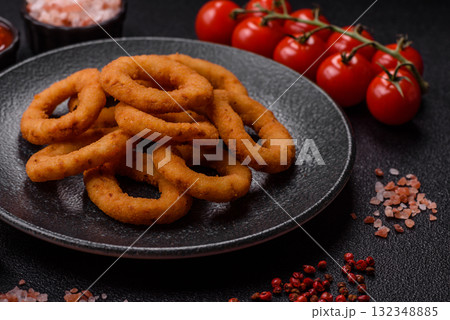 Onion rings or fried squid in breadcrumbs with sauce, takeaway food. Onion rings fried Onion rings or fried squid in breadcrumbs with sauce, takeaway food. Onion rings fried 132348885