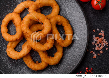 Onion rings or fried squid in breadcrumbs with sauce, takeaway food. Onion rings fried Onion rings or fried squid in breadcrumbs with sauce, takeaway food. Onion rings fried 132348886