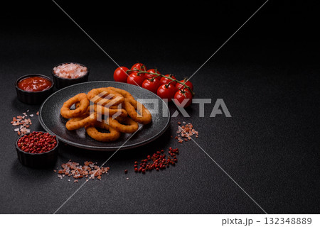 Onion rings or fried squid in breadcrumbs with sauce, takeaway food. Onion rings fried 132348889
