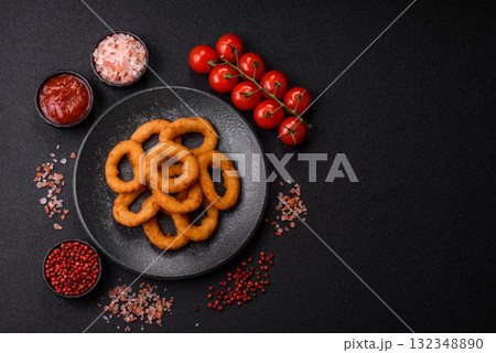 Onion rings or fried squid in breadcrumbs with sauce, takeaway food. Onion rings fried 132348890