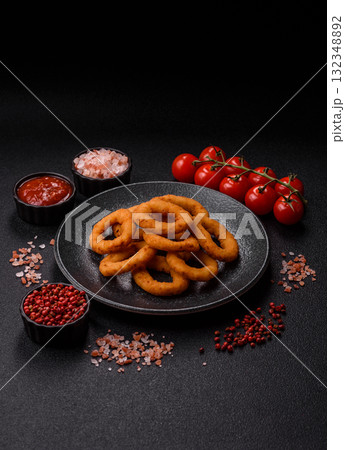 Onion rings or fried squid in breadcrumbs with sauce, takeaway food. Onion rings fried 132348892