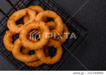 Onion rings or fried squid in breadcrumbs with sauce, takeaway food. Onion rings fried 132348900