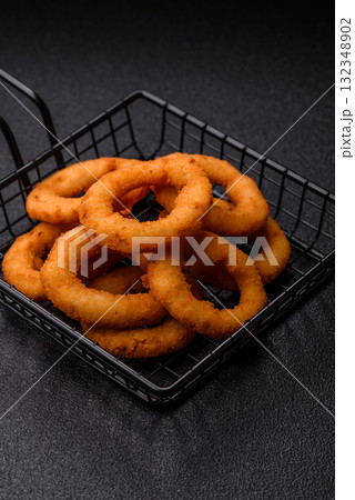 Onion rings or fried squid in breadcrumbs with sauce, takeaway food. Onion rings fried 132348902