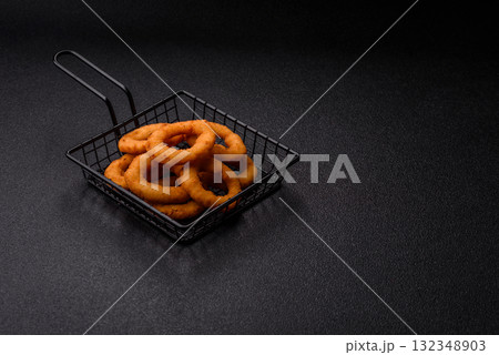 Onion rings or fried squid in breadcrumbs with sauce, takeaway food. Onion rings fried Onion rings or fried squid in breadcrumbs with sauce, takeaway food. Onion rings fried 132348903