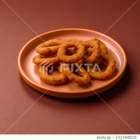 Onion rings or fried squid in breadcrumbs with sauce, takeaway food. Onion rings fried Onion rings or fried squid in breadcrumbs with sauce, takeaway food. Onion rings fried 132348910