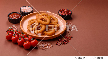 Onion rings or fried squid in breadcrumbs with sauce, takeaway food. Onion rings fried 132348919