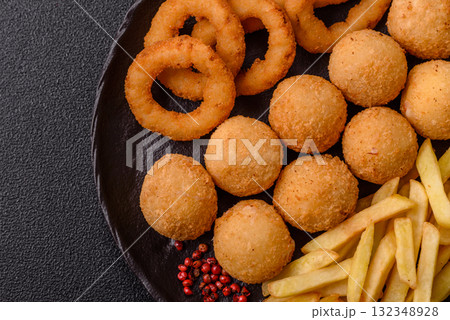 Fast food, cheese balls, onion or squid rings and French fries. Junk food as a background Fast food, cheese balls, onion or squid rings and French fries. Junk food as a background 132348928