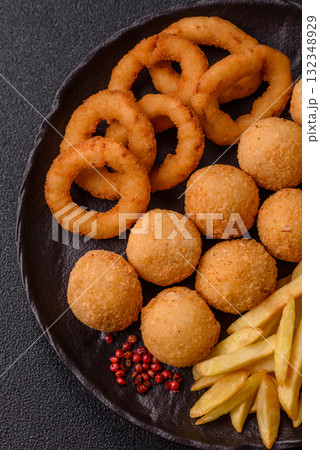 Fast food, cheese balls, onion or squid rings and French fries. Junk food as a background Fast food, cheese balls, onion or squid rings and French fries. Junk food as a background 132348929