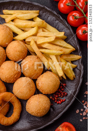 Fast food, cheese balls, onion or squid rings and French fries. Junk food as a background 132348933