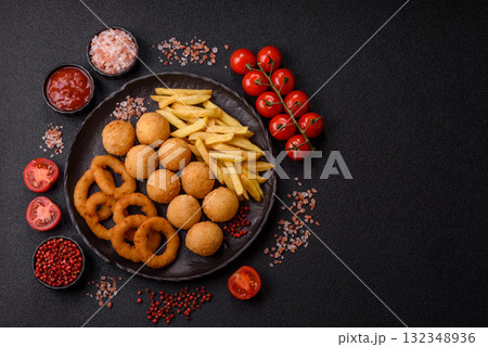 Fast food, cheese balls, onion or squid rings and French fries. Junk food as a background Fast food, cheese balls, onion or squid rings and French fries. Junk food as a background 132348936