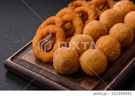 Fast food, cheese balls, onion or squid rings and French fries. Junk food as a background Fast food, cheese balls, onion or squid rings and French fries. Junk food as a background 132348942