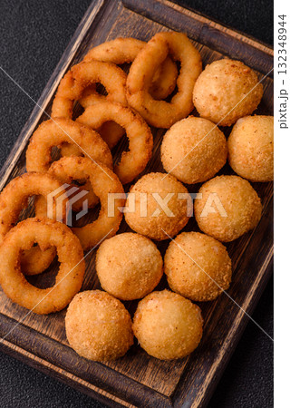 Fast food, cheese balls, onion or squid rings and French fries. Junk food as a background Fast food, cheese balls, onion or squid rings and French fries. Junk food as a background 132348944