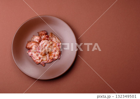 Cooked crispy fried pork bacon strips for a hearty breakfast. Fried bacon strips Cooked crispy fried pork bacon strips for a hearty breakfast. Fried bacon strips 132349501