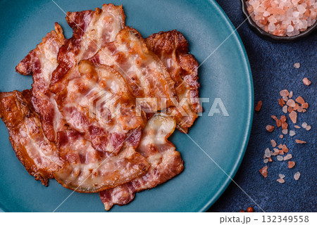 Cooked crispy fried pork bacon strips for a hearty breakfast. Fried bacon strips Cooked crispy fried pork bacon strips for a hearty breakfast. Fried bacon strips 132349558