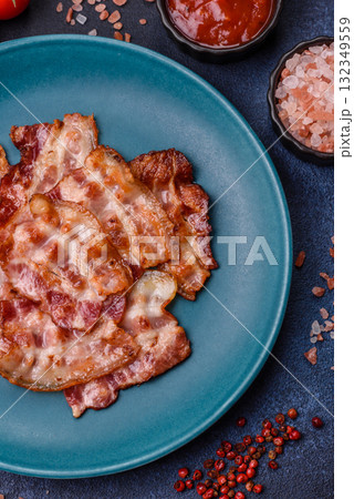 Cooked crispy fried pork bacon strips for a hearty breakfast. Fried bacon strips Cooked crispy fried pork bacon strips for a hearty breakfast. Fried bacon strips 132349559