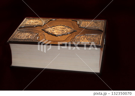 Ancient book in luxurious binding isolated on black background Ancient book in luxurious binding isolated on black background 132350070
