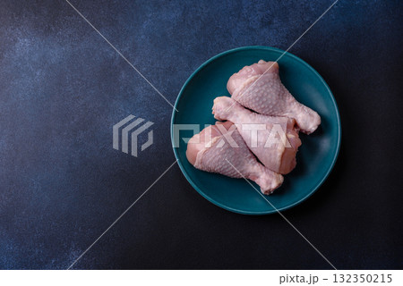 Raw chicken or turkey legs as a food background for cooking on a barbecue or grill. Chicken raw legs Raw chicken or turkey legs as a food background for cooking on a barbecue or grill. Chicken raw legs 132350215