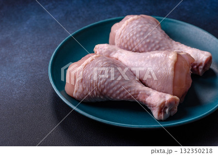 Raw chicken or turkey legs as a food background for cooking on a barbecue or grill. Chicken raw legs Raw chicken or turkey legs as a food background for cooking on a barbecue or grill. Chicken raw legs 132350218