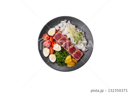 Seafood bowl, tuna tataki fillet slices with rice, oranges, tomatoes and sauce. Tuna bowl 132350371