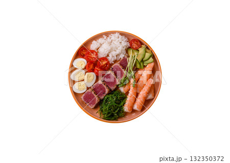Seafood bowl, tuna tataki fillet slices with rice, oranges, tomatoes and sauce. Tuna bowl 132350372