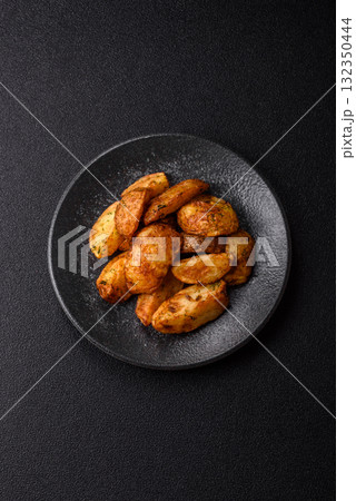 Potato wedges baked with spices, garlic and rosemary. Potato wedges 132350444