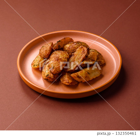 Potato wedges baked with spices, garlic and rosemary. Potato wedges 132350461
