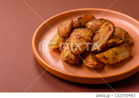 Potato wedges baked with spices, garlic and rosemary. Potato wedges Potato wedges baked with spices, garlic and rosemary. Potato wedges 132350462