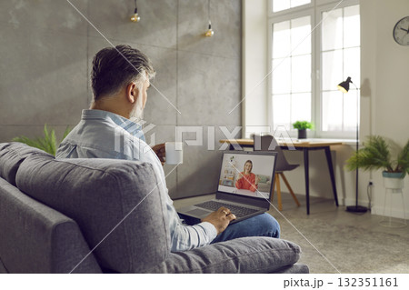Gray haired bearded businessman talking with young woman using laptop 132351161