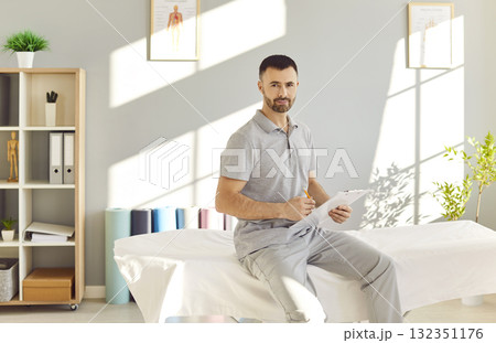 Physical therapist sitting on couch in rehabilitation hospital and looking at camera. Physical therapist sitting on couch in rehabilitation hospital and looking at camera. 132351176