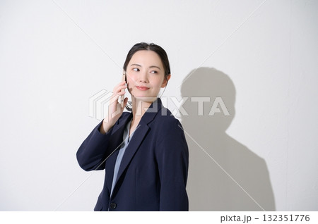 白背景でスマホで通話をする女性 132351776