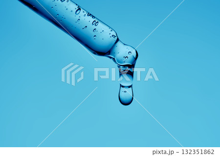 A serum pipette with lots of bubbles on a blue background. 132351862