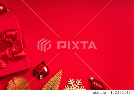 Clean red background with a gift box and ribbon bow at the bottom. Very large copy space for banners, headers, seasonal promotions and greetings - perfect for simple layouts. Clean red background with a gift box and ribbon bow at the bottom. Very large copy space for banners, headers, seasonal promotions and greetings - perfect for simple layouts. 132352145