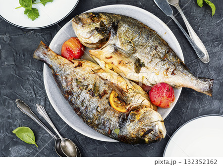 Grilled dorado fish with plums. 132352162