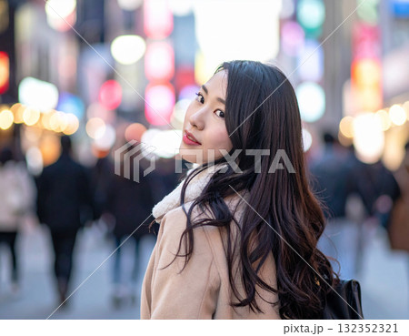 雑踏の中で振り返る若い女性の笑顔 雑踏の中で振り返る若い女性の笑顔 132352321