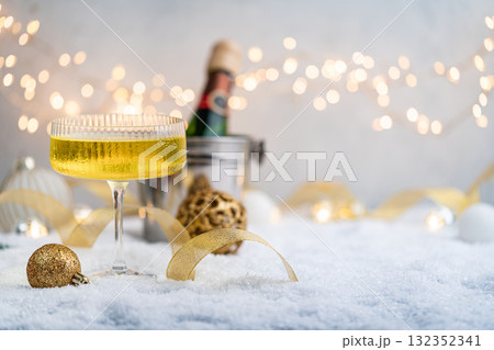 Champagne Glass and Bottle on Snow with Festive Lights 132352341