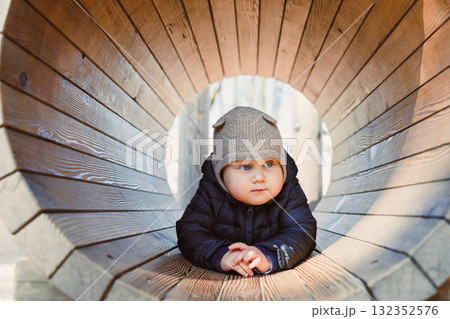 Child walking outdoors. Happy toddler boy on a walk on the playground. Child development, healthy lifestyle of the child. Boy outdoors on an autumn walk. Cheerful boy in the city park. Child walking outdoors. Happy toddler boy on a walk on the playground. Child development, healthy lifestyle of the child. Boy outdoors on an autumn walk. Cheerful boy in the city park. 132352576