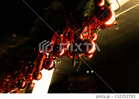 Christmas red baubles hanging from the roof edge as festive outdoor decoration Christmas red baubles hanging from the roof edge as festive outdoor decoration 132352703