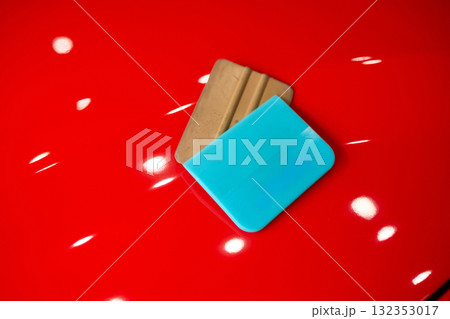 Brightly Colorful Squeegees Arranged on a Glossy Red Surface for Creative Appealing Displays 132353017