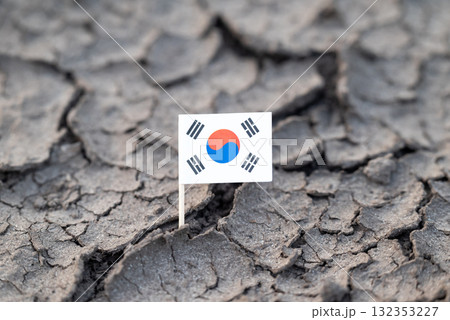 Flag of Republic of Korea on dry cracked soil. Concept of drought in Korea, rainless season, lack of water 132353227