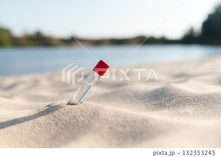 Water sample in sand on river beach. Water purity analysis, testing for infections, chemicals Water sample in sand on river beach. Water purity analysis, testing for infections, chemicals 132353245