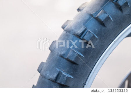Front wheel of enduro motorbike with worn tire. Motorbike needs maintenance, tire have to be replaced with new one with big spikes Front wheel of enduro motorbike with worn tire. Motorbike needs maintenance, tire have to be replaced with new one with big spikes 132353326