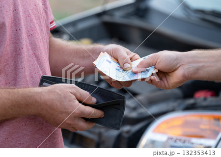 Spending all money for fixing car, high price for service and maintenance of vehicle. Car owner paying service mechanic at garage workshop for fixing broken down car 132353413