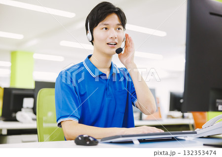 ヘッドセットをつけてコールセンターで働く男性 132353474
